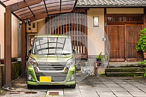 Japanese Style entrance to the wooden house with kei car type parked in from of it