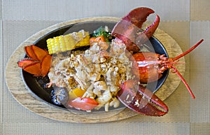 Japanese style lobster steak served on a hot pan with buttered  vegetables as a side dish. Top view