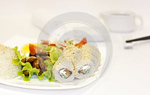 Japanese-style lunch with teriyaki chicken, rice, fresh vegetables and rolls