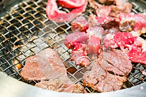 Japanese style Raw fresh beef on hot barbecue grill .