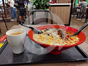 Japanese style seafood noodles in red bow and Chinese tea in a restaurant in university student canteen in Hong Kong HKU
