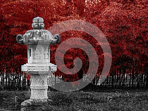 Japanese style stone at Lennox Gardens, Canberra with a red plant background