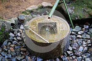 Japanese style traditional bamboo fountain at Ryoan-ji temple in Kyoto, Japan