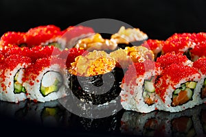 Japanese Sushi  on black background. Reflection in a mirror surface. Close up. Studio photo