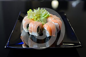 Japanese sushi on a black plate.