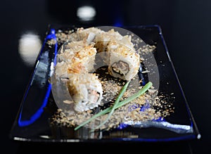 Japanese sushi on a black plate.