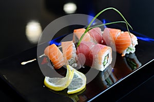 Japanese sushi on a black plate.