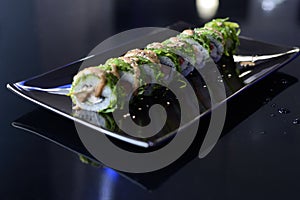 Japanese sushi on a black plate.