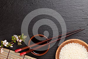 Japanese sushi chopsticks, soy sauce bowl, rice and sakura blossom