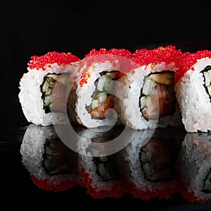 Japanese Sushi isolated on black background. Reflection in a mirror surface. Close up. Studio photo
