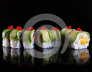 Japanese Sushi isolated on black background. Reflection in a mirror surface. Close up. Studio photo