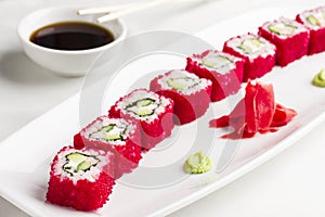 Japanese sushi rolls with avocado in red caviar of flying fish