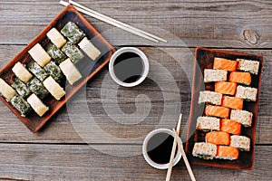 Japanese sushi rolls, chopsticks and sauce bowls