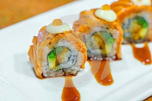 Japanese Sushi rolls with fresh raw salmon on white plate .