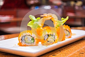 Japanese Sushi rolls with fresh raw salmon on white plate .