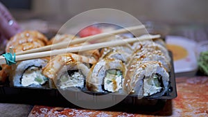 Japanese Sushi Rolls in Plastic Box are Served on Table with Bamboo Sticks. 4K