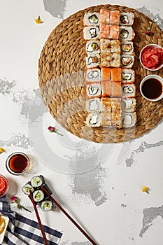 Japanese Sushi - Set of Maki Sushi Roll, Soy Sauce and Ginger over White Texture Background