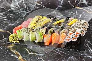 Japanese sushi set. Set of fresh tuna maki , salmon nigiri and dragon sushi rolls served on black plate close-up. Horizontal top