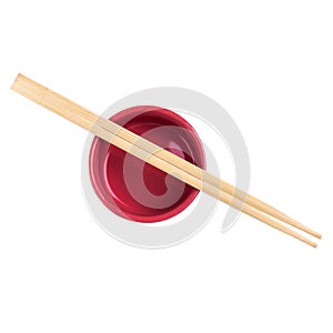 Japanese sushi sticks or chopsticks over red sauce bowl isolated on white background. Top view