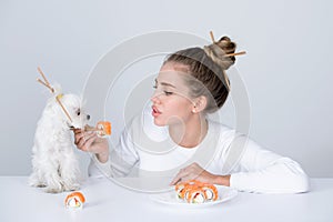 Japanese sushi style. Fashion portrait of beauty model girl eating sushi rolls, japanese food. Beautiful woman holding