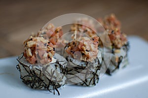 Japanese sushi with tuna and algae. Close up of sushi rolls on white plate.