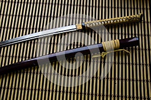 Japanese sword katana and sheath on bamboo mat