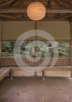 Japanese tea house lit by a lantern of paper overlooking a water