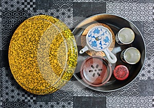 japanese tea set with cups, tea-pot and chakoboshi recipient stored in a golden lacquer box on a fabric.