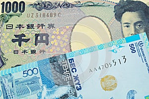 A Japanese thousand yen note paired with a blue, plastic five hundred tenge bank note from Kazakstan.