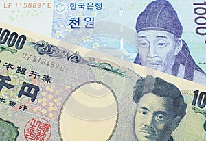 A Japanese thousand yen note paired with a blue and white one thousand won bill from Korea.