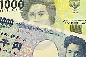 A Japanese thousand yen note paired with a green one thousand bank note from Indonesia.