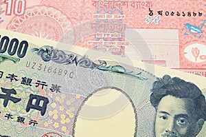 A Japanese thousand yen note paired with a red ten taka bank note from Bangladesh.