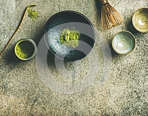 Japanese tools for brewing matcha green tea, grey concrete background