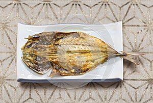 Japanese traditional grilled fish on a silver pattern table cloth.