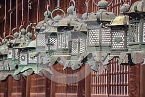 Japanese traditional steel lanterns hanging around at wooden building of Kasuga Shrine, Nara.