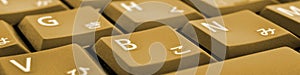 Japanese typing. Dark yellow laptop keyboard closeup. Symbols on buttons of hiragana. Light brown tinted computer header or banner
