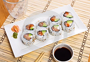 Japanese Uramaki and California rolls served in a plate with soya sauce photo
