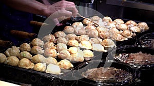 Japanese vendor prepare a Takoyaki on hot pan food in Osaka, Japan.