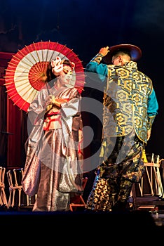 Japanese woman geisha in traditional kimono and meets and Kino Kitsune fox mask greets man