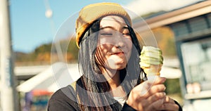 Japanese woman, ice cream and eating in city, summer and walk with thinking, memory or ideas on vacation. Girl, person