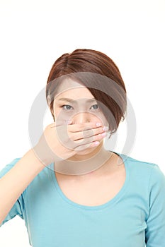 Japanese woman making the speak no evil gesture