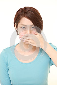 Japanese woman making the speak no evil gesture