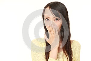 Japanese woman making the speak no evil gesture