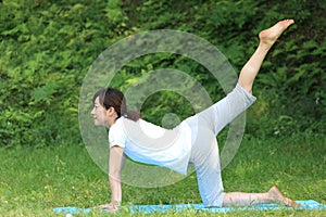 Japanese woman outside doing yoga cat pose