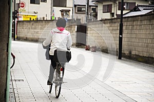 Japanese woman riding bicycle on the road in Saitama, Japan.