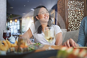 Japanese woman, sushi restaurant and smile for eating, thinking and conversation for fine dining at party. Asian friends