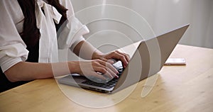 A Japanese woman typing laptop by remote work in the office faceless composition