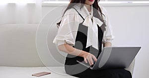 A Japanese woman typing laptop by remote work in the office faceless composition