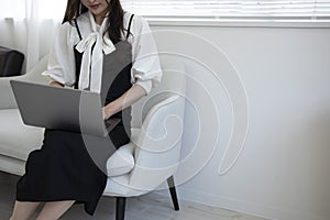 A Japanese woman typing laptop by remote work in the office faceless composition