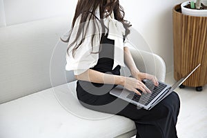 A Japanese woman typing laptop by remote work in the office faceless composition